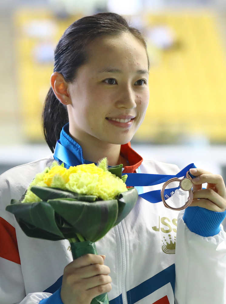 女子３メートル飛板飛込決勝、３位になりメダルを手に笑顔を見せる馬淵