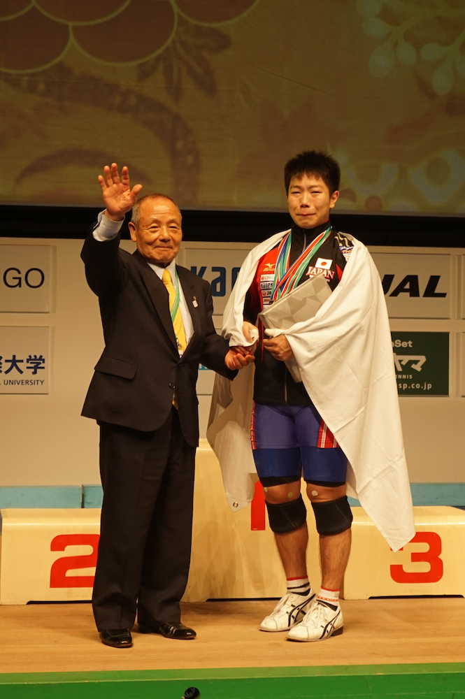 ジュニア世界選手権で銀メダルを獲得し、東京国際大の三宅義信監督と握手する宮本昌典