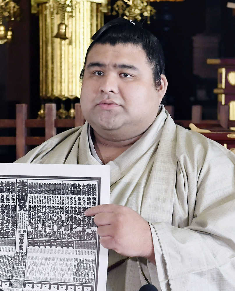 大相撲名古屋場所の番付表を手に、記者会見する新大関の高安
