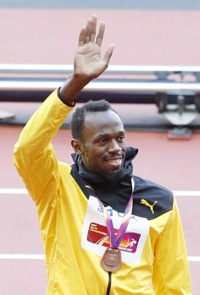 男子１００メートルの表彰式後、銅メダルを胸にスタンドの声援に応えるウサイン・ボルト