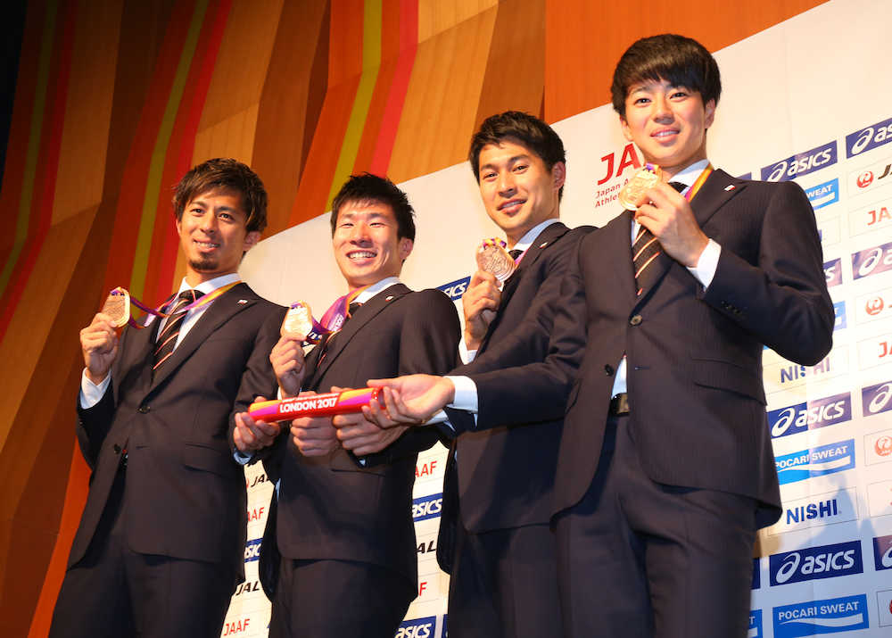 帰国し、バトンと銅メダルを掲げる（左から）藤光、桐生、飯塚、多田
