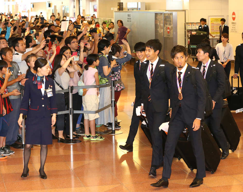 大勢のファンに見守られ帰国する男子４００メートルリレー銅メダリストの（左から）多田、飯塚、藤光、桐生