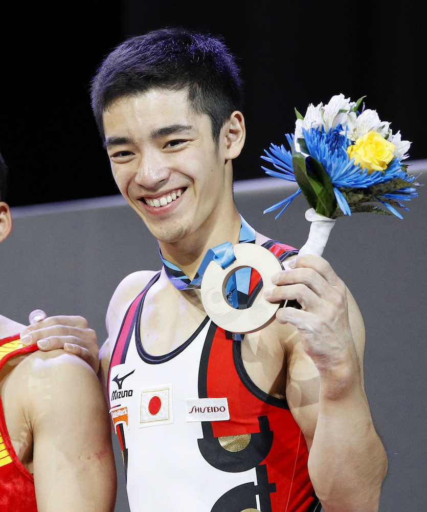 体操の世界選手権男子個人総合で獲得した銅メダルを手に笑顔の白井健三