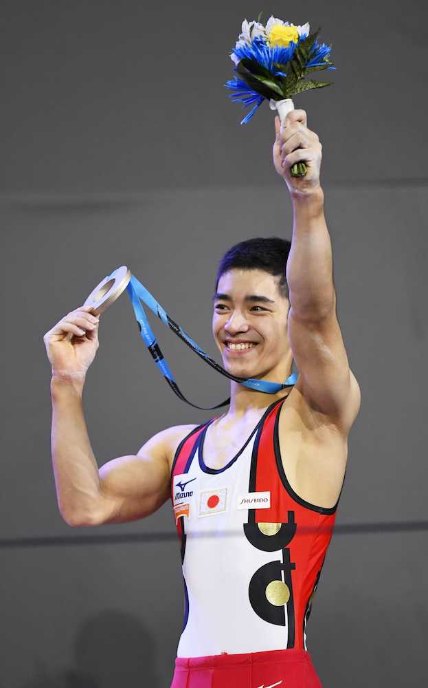 男子個人総合で銅メダルを獲得し、笑顔の白井健三