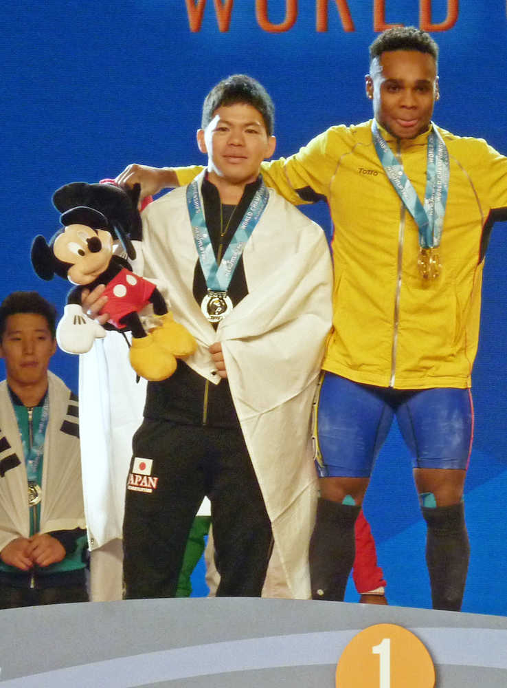 重量挙げ世界選手権男子６２キロ級で銀メダルを獲得、表彰台に立つ糸数（左）