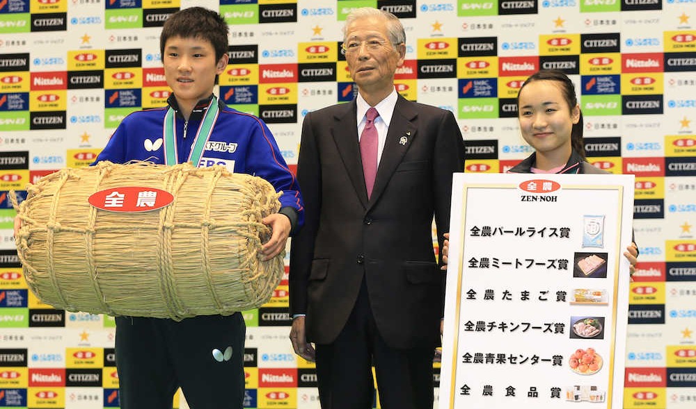 全農・長澤経営管理委員会会長（中央）から豪華な副賞の目録を受け取り笑顔の男女シングルス優勝の張本（左）と伊藤