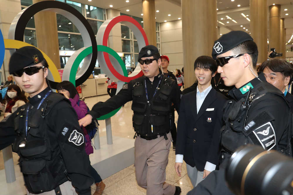 空港内にあるオリンピックシンボルの前を笑顔で歩く羽生結弦（撮影・椎名　航）