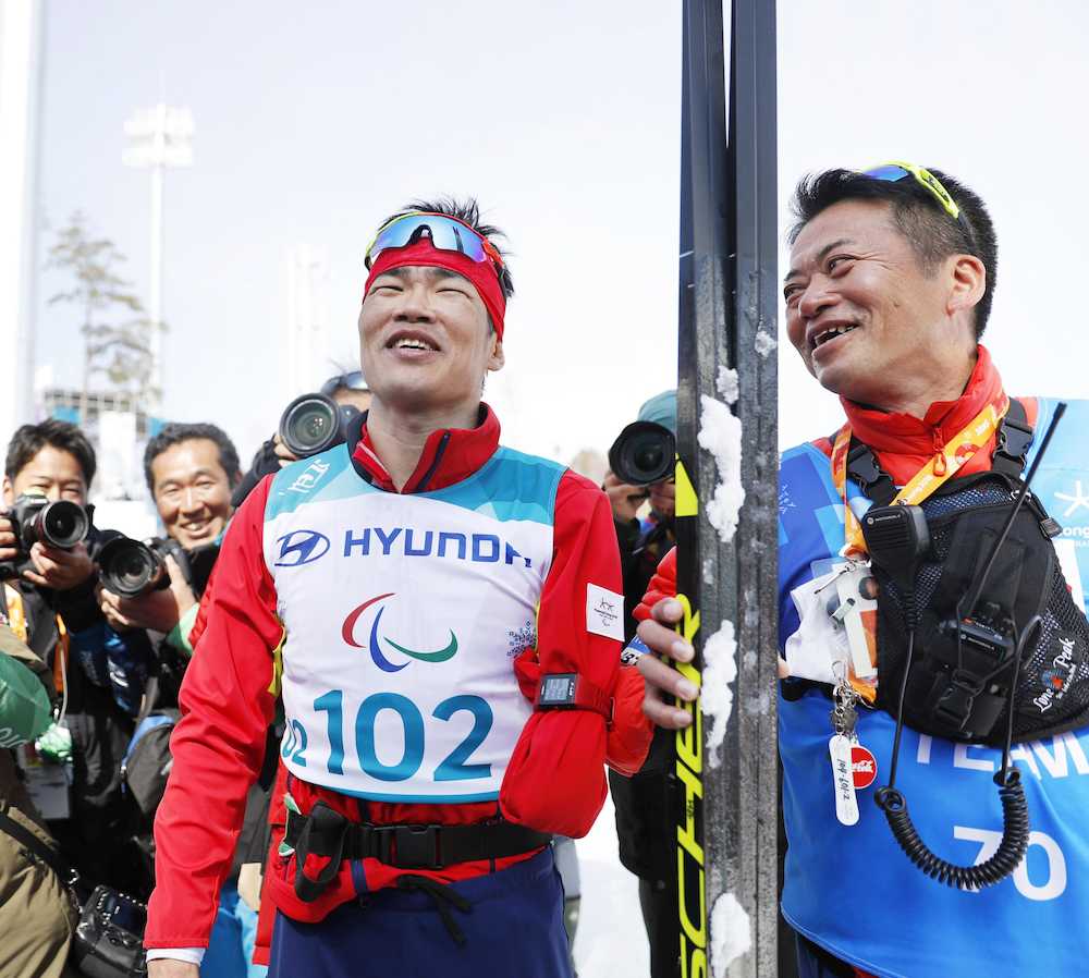 平昌パラリンピックスキー距離男子１０キロクラシカル立位で金メダルを獲得し、ほっとした表情の新田（左）と笑顔の荒井監督