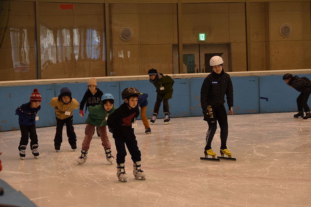 子どもたちの滑りを温かく指導する斎藤選手（右）