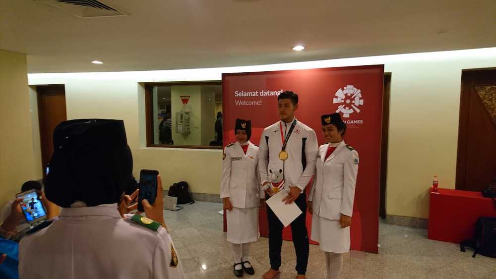 アジア大会の柔道男子１００キロ級を制し、表彰式後に女性スタッフとの写真撮影に応じる飯田健太郎