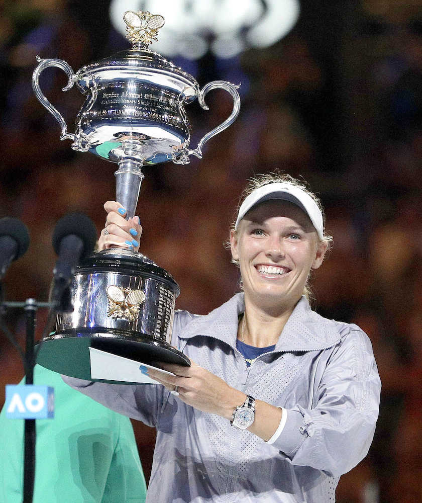 全豪テニス女子シングルスで優勝し、笑顔でトロフィーを掲げるキャロライン・ウォズニアッキ