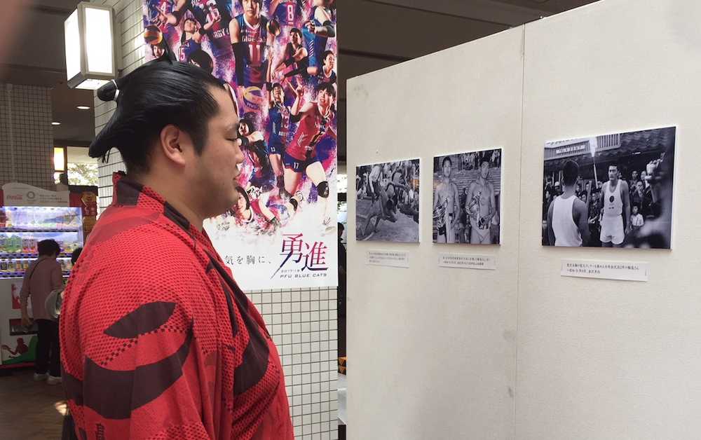 秋巡業の金沢市の会場に展示された輪島さんの写真を眺める輝