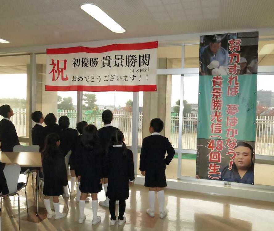 貴景勝の初優勝横断幕を見上げる母校・仁川学院の児童たち