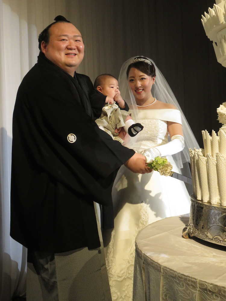 長男・慶丞ちゃんを抱いてウェディングケーキに入刀する宝富士と英莉乃夫人