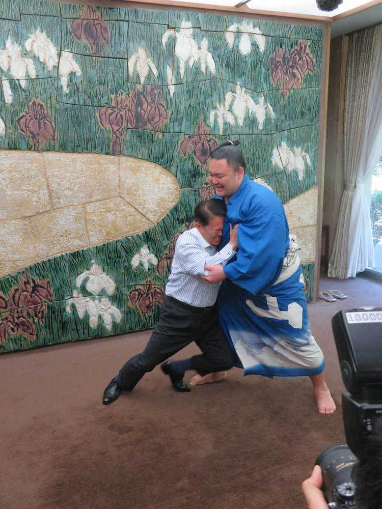 表敬訪問後、相撲を取り、大村秀章知事（左）のぶつかりを受け止める朝乃山