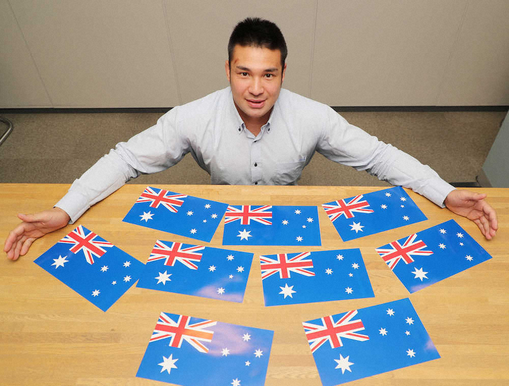 オーストラリアの国旗を前に大きく手を広げる高木（撮影・木村　揚輔）