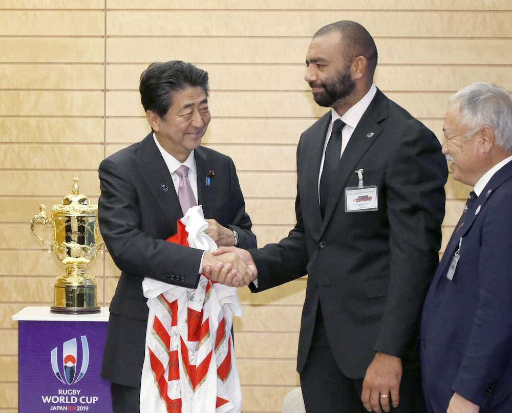 安倍首相と握手するラグビー日本代表のリーチ・マイケル主将（中央）
