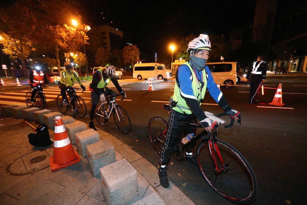 東京五輪マラソン・競歩の会場となる札幌市で行われたコース計測。世界陸連の関係者らが自転車に乗ってマラソンコースを計測した＝10日未明1時56分、同市中央区の大通公園周辺（代表撮影）