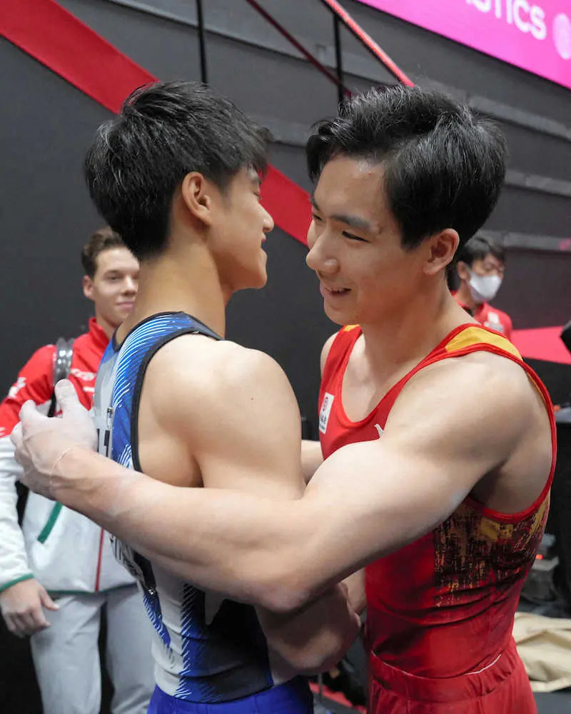 男子個人総合決勝の演技終了後、橋本大輝（左）に言葉を掛ける中国の張博恒（代表撮影）