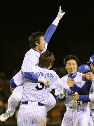 サヨナラ打を放ち、同点打の吉村と抱き合って喜ぶ横浜・仁志（左上）
