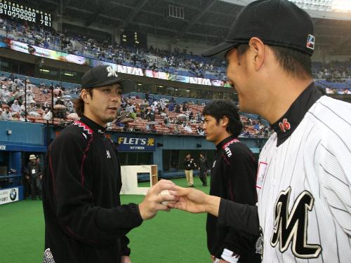 ＜ロッテ・横浜＞２勝目をあげた小林宏（左）はリリーフにまわった久保からウイニングボールを贈られる