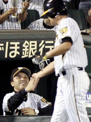 ４回、今岡の二塁打で生還した安藤（右）をベンチで迎える阪神・岡田監督