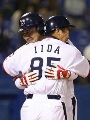 ＜ヤ・横＞８回、小野（奥）は決勝の左越え本塁打を放ち飯田コーチに出迎えられる