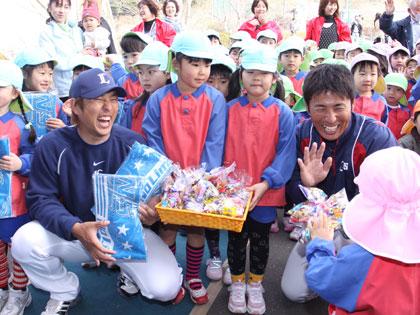 練習前、地元の幼稚園児からチョコレートをプレゼントされ笑顔を見せる中島裕之（左）と赤田将吾