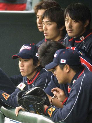 ベンチで巨人との練習試合を見詰める、岸（前列左）、細川（右手前）、和田（後列中）