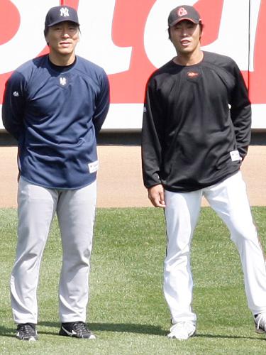 試合前の練習中に外野で談笑する松井秀喜と上原浩治（右）
