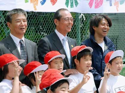 野球の楽しさを伝える活動に訪れた熊本市内の小学校で、児童らと記念写真に納まるソフトバンクの王貞治会長（中）ら