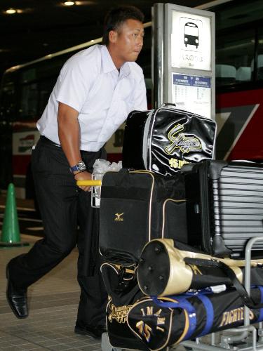 1軍に昇格した中田翔は新千歳空港に到着し、カートで荷物を運ぶ