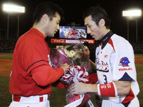試合後、ヤクルトの福地外野手（右）から花束を受け取る、今季限りで現役を引退する広島の緒方外野手