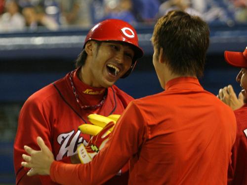 ＜ヤ・広＞８回、勝ち越しとなる左越え本塁打を打った栗原健太（左）は前田健太からバナナをプレゼントされ大笑い