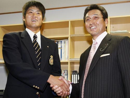 阪神から１位指名され、あいさつに訪れた真弓監督（右）と笑顔で握手する法大の二神一人投手
