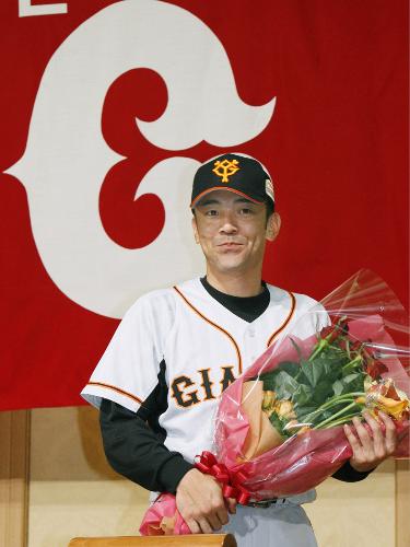 記者会見を終え、花束を手にする今季限りで現役引退を表明した巨人・木村拓也