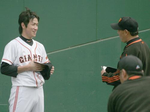 ブルペンで２００球の投げ込みを行った後、斎藤投手コーチ（右）と笑顔で話す巨人山口