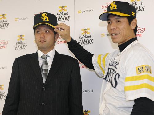 ソフトバンクに移籍し、入団会見で秋山監督（右）から帽子をかぶせてもらう吉川輝昭投手