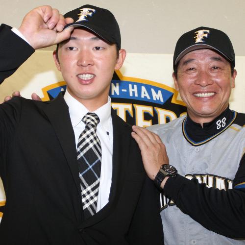 ＜ロ・日＞日本ハムにトレードで移籍した佐藤賢治外野手（左）は梨田監督と笑顔でポーズをとる