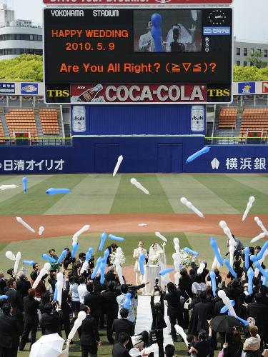 横浜スタジアムで行われた結婚式で、ジェット風船を飛ばして祝福する参列者ら＝