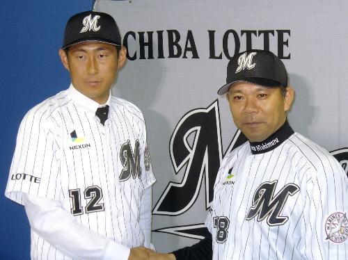 入団会見でロッテの西村監督（右）と握手する、横浜から移籍した吉見