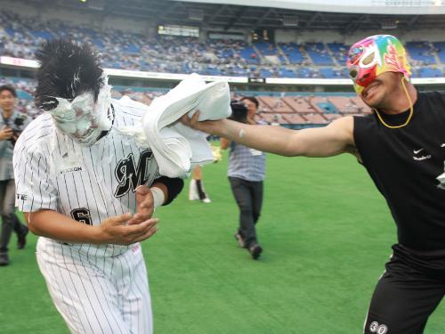 ＜ロ・神＞サヨナラ本塁打を放った井口（左）は的場扮するマスクマンからシェービングクリームの襲撃を顔に受ける　