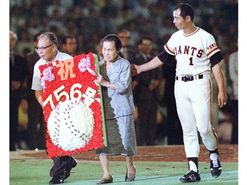１９７７年９月３日、後楽園球場で本塁打世界新記録を達成し、セレモニーで王貞治選手から花の盾を渡された両親の仕福さんと登美さん（中央）