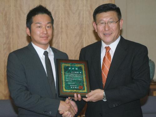 秋田県のスポーツ大使に就任し、佐竹敬久知事（右）と握手するヤクルトの石川雅規投手