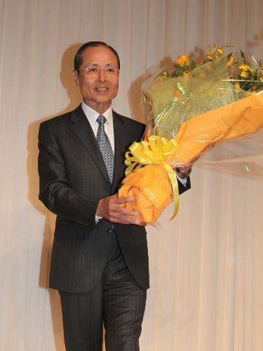 花束を会員から花束をもらい笑顔の王会長