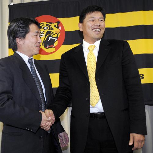 阪神の２軍投手コーチ就任を発表し、高野栄一球団副本部長（左）と握手を交わす藪恵壹投手
