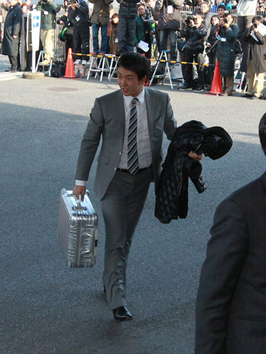 多くの報道陣を背にリモワの鞄を持って寮に入る日本ハム・斎藤（中）