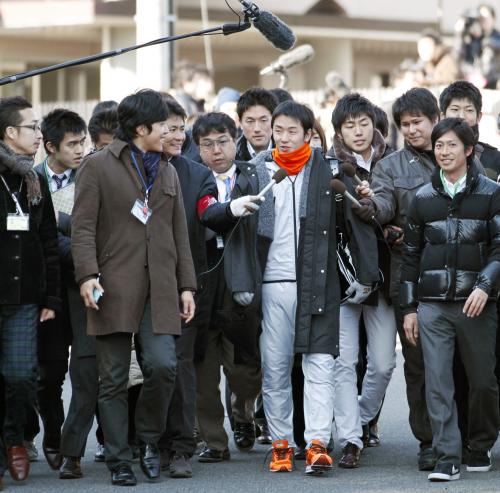 報道陣に囲まれながら球場へ向かう日本ハムの斎藤佑樹投手（中央）