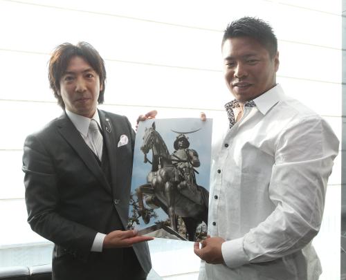 楽天・岩村（右）が伊達家１３代目当主・宗信氏と対面し、仙台の伊達政宗公像の写真を手にする