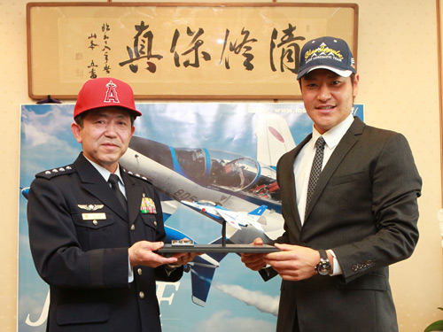 航空幕僚長岩崎茂空将（左）とそれぞれブルーインパルス、エンゼルスの帽子を交換した高橋尚成（右）は、空将とともにブルーインパルスの模型を手にし記念撮影